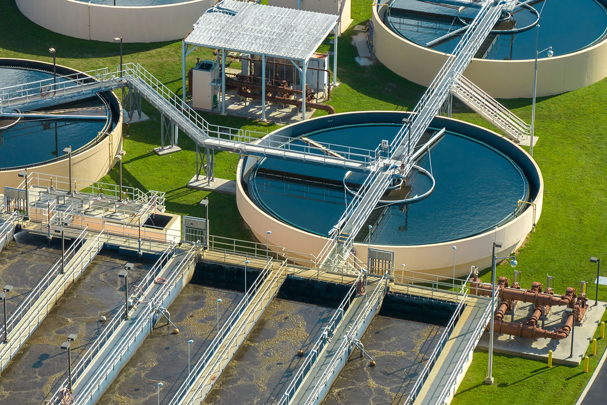 Aerial view of modern municipal water treatment facility with clarification tanks and filtration systems for PFAS removal